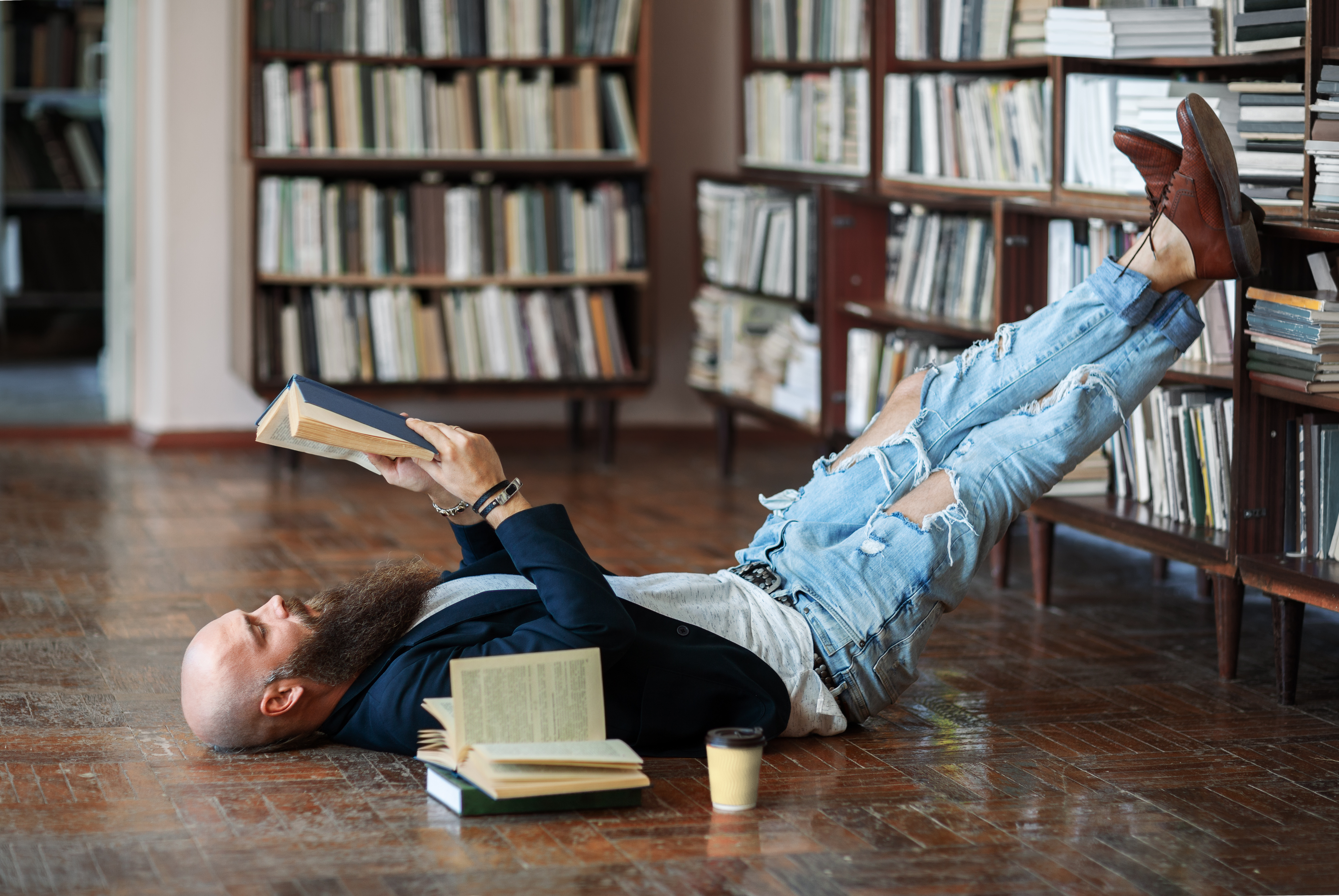 Читать лежа вредно лежа на горячем песке. Книги лежат на полу. Книга лежит. Человек валяется в книгах. Чтение книги на полу.